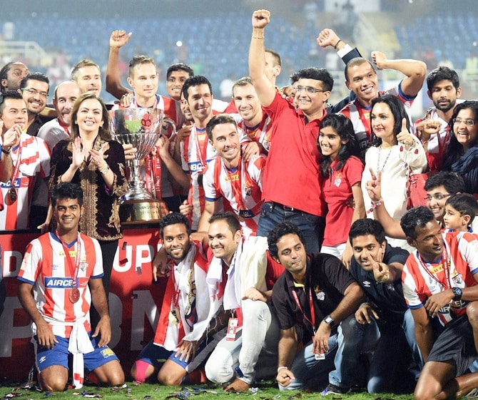 Navi Mumbai: Former Indian cricket captain and co-owner of ISL franchise Atletico de Kolkata Sourav Ganguly and his team pose for a picture as they celebrate after winning the Indian Super League final match against Kerala Blaster FC in Navi Mumbai on Saturday. ISL founding chairperson Nita Ambani is also seen. PTI Photo by Santosh Hirlekar(PTI12_20_2014_000229B)
