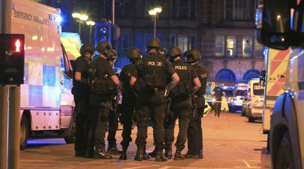 Armed police gather at Manchester Arena after reports of an explosion at the venue during an Ariana Grande gig in Manchester, England Monday, May 22, 2017. Several people have died following reports of an explosion Monday night at an Ariana Grande concert in northern England, police said. A representative said the singer was not injured. (Peter Byrne/PA via AP)