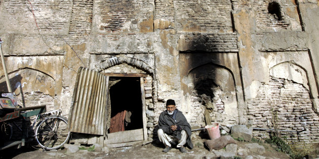 Sikander Shah,70, a Kashmiri man sits at the entrance of his house inside the ruins of Dara Shikuh monument in Srinagar March 8, 2007. The couple arrived in the ruins of the 440 years old monument, which was built by Mughal prince Dara Shikuh, about 38 years ago and now live there with their four children and two grandchildren, the couple said. Picture taken March 8, 2007. REUTERS/Danish Ismail (INDIAN-ADMINISTERED KASHMIR)