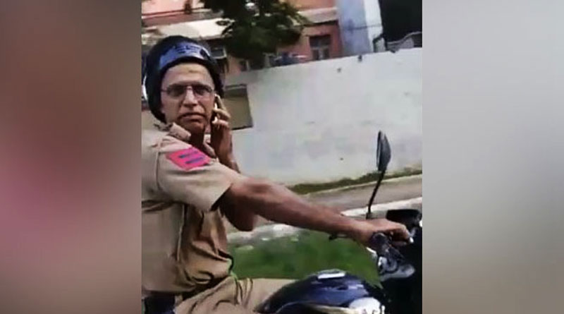 মোবাইল কানে বাইকে সওয়ার পুলিশ, ভিডিও তোলায় জুটল থাপ্পড়