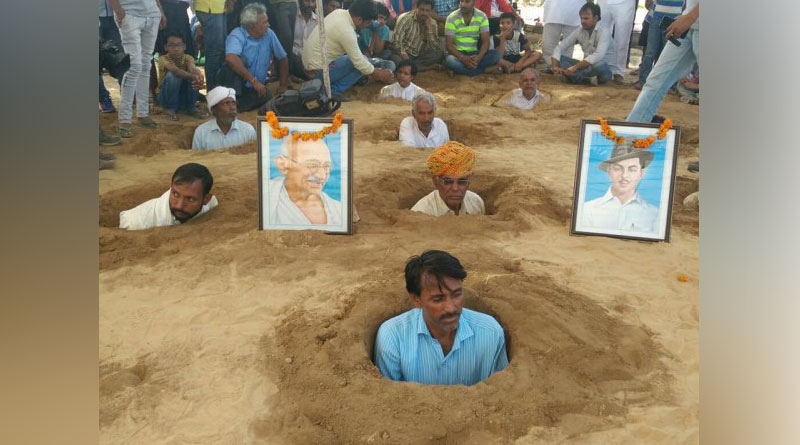 জমি অধিগ্রহণের প্রতিবাদে নিজেদের গলা পর্যন্ত কবর দিচ্ছেন চাষিরা