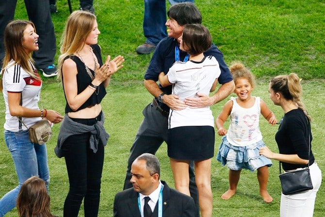 RIO DE JANEIRO, BRAZIL - JULY 13: Head coach Joachim Loew of Germany hugs Kathrin Gilch, girlfriend of Manuel Neuer of Germany, as Montana Yorke, girlfriend of Andre Schuerrle of Germany, and Sarah Brandner, girlfriend of Bastian Schweinsteiger of Germany, look on during the 2014 FIFA World Cup Brazil Final match between Germany and Argentina at Maracana on July 13, 2014 in Rio de Janeiro, Brazil. (Photo by Jamie Squire/Getty Images)