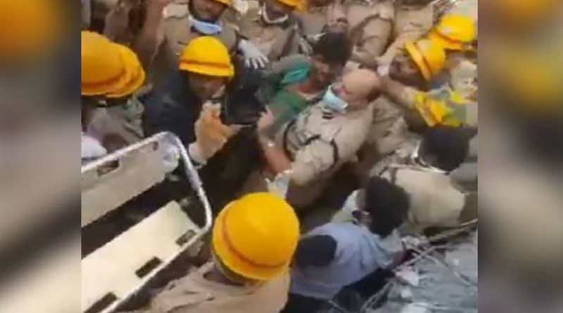 Man being pulled out from Dharwad building rubble.
