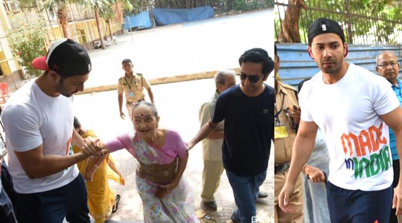 Varun Dhawan helping an old lady to climb up the stairs at polling booth