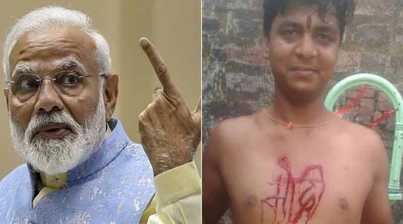 A youth uses knife to carve Narendra Modi's name on his chest