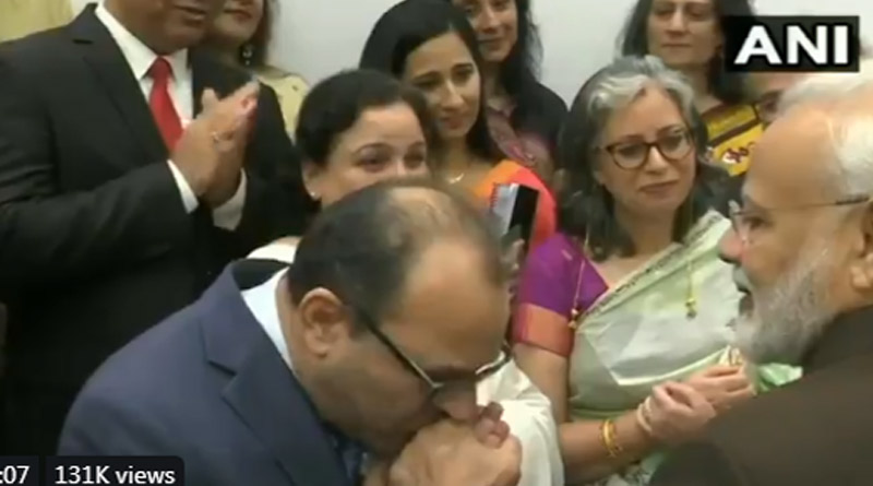 A member kisses PM Modi's hands and says, Thank you