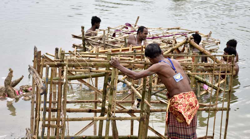 A number of youth takes the structures of idol from the river and keep it clean