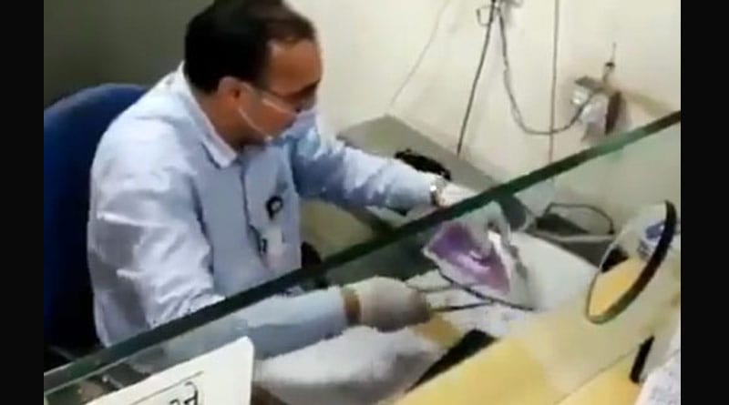 করোনা সংক্রমণ রুখতে ইস্ত্রি দিয়ে চেক জীবাণুমুক্ত করছেন ব্যাংক কর্মী! দেখুন ভিডিও