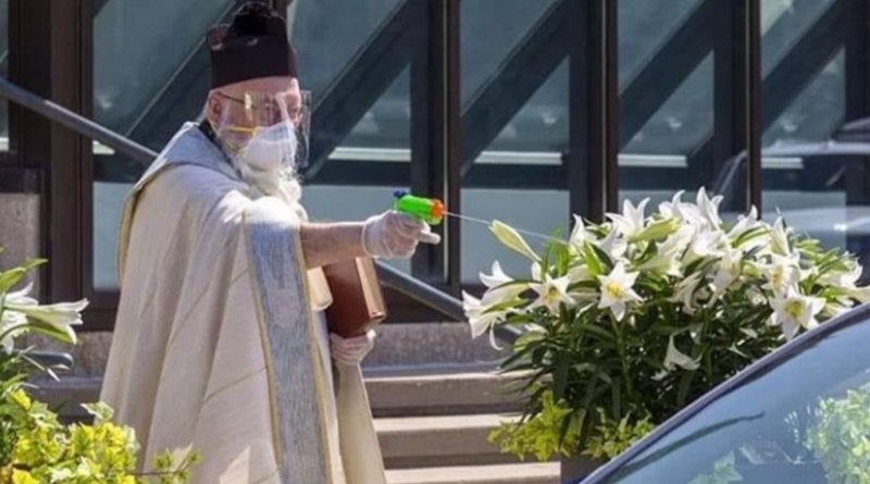 Priests sprays holy water with toy gun to maintain social distance