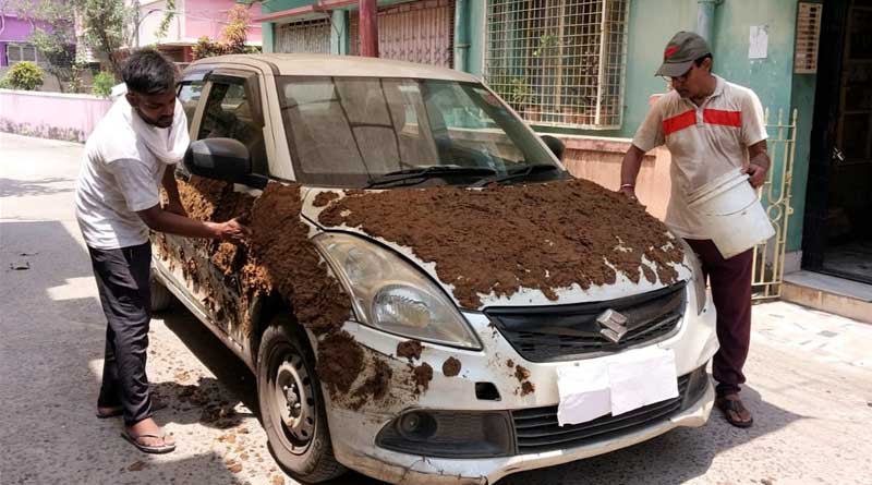 Car owner applies cowdung outside the car to keep it cool during this hot summer | Sangbad Pratidin