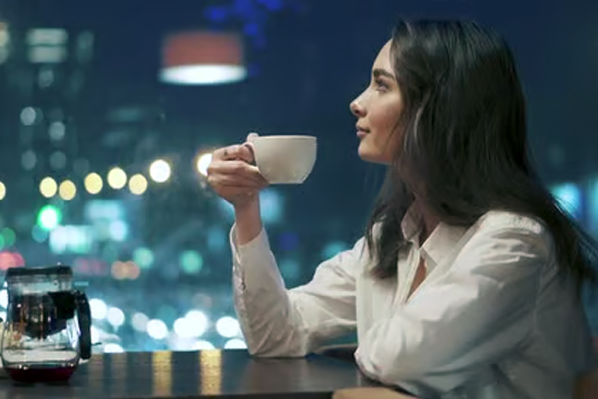  woman drinking coffee at night causing sleep disruption