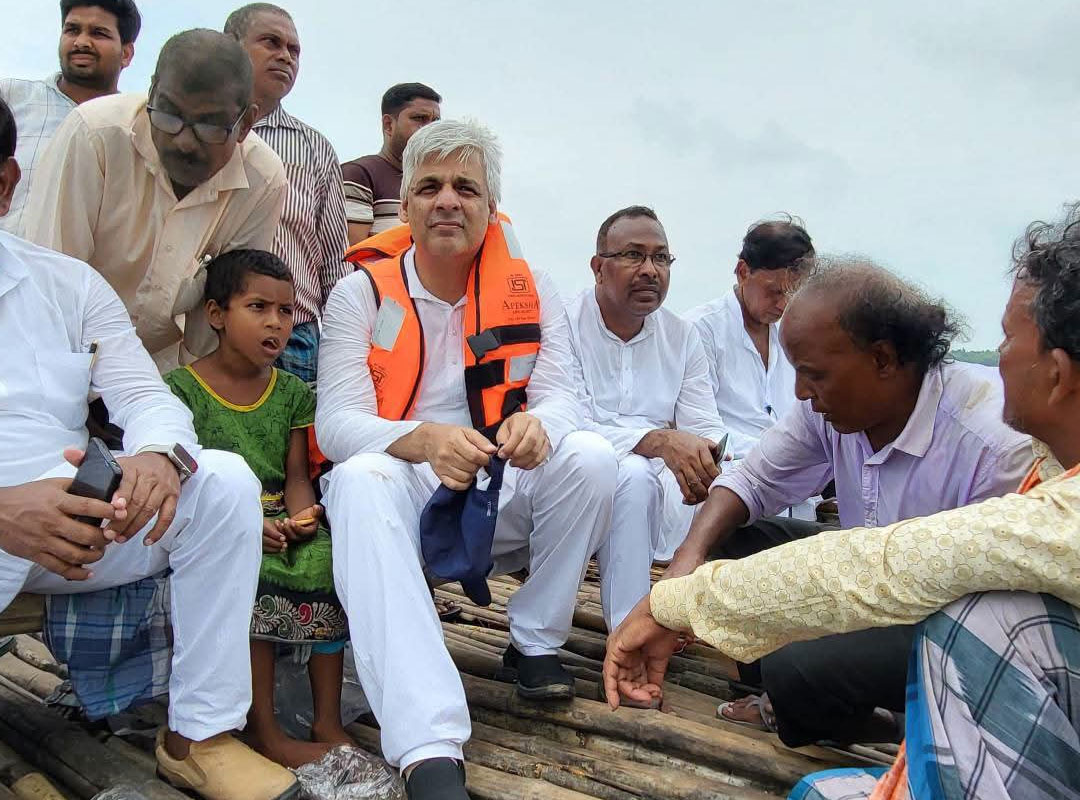 government doctor is examining patients while floating in a boat, wearing a life jacket, in Bhutni, Maldah